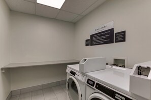 A laundry area with a washing machine, dryer, and a sign indicating guest use only. - Hilton Garden Inn Fort Worth / Fossil Creek (Fort Worth)