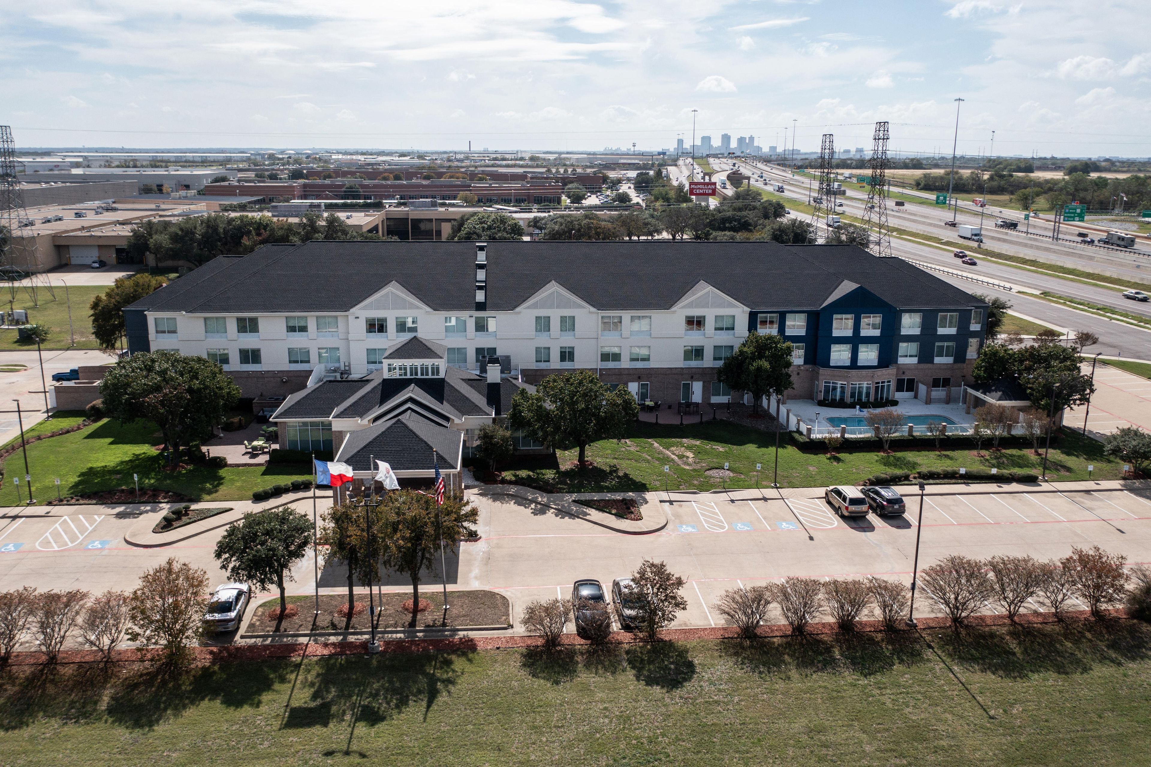 A multi-story building with a parking lot in front.