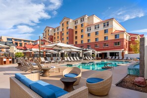 A hotel pool area with lounge chairs, umbrellas, and a swimming pool. - Hilton Garden Inn Scottsdale Old Town (Scottsdale)