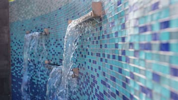 A tiled wall with a water feature.