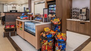 A snack bar with various packaged snacks and a refrigerated display. - Hilton Garden Inn Scottsdale Old Town (Scottsdale)