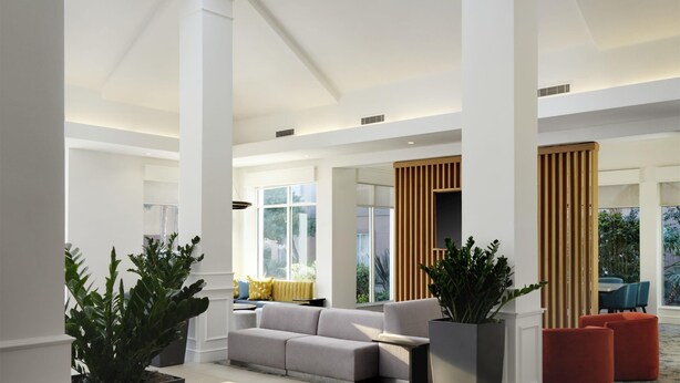 A spacious lobby with high ceilings, large windows, and modern lighting fixtures. - Hilton Garden Inn San Jose/Milpitas (Milpitas)