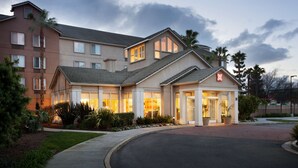A multi-story hotel with a modern design, featuring a well-lit entrance and landscaped surroundings. - Hilton Garden Inn San Jose/Milpitas (Milpitas)