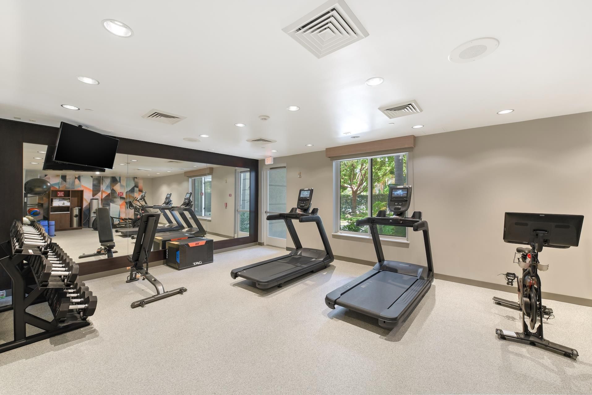 A gym with treadmills, a rowing machine, and a weight bench.