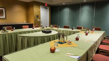 A conference room with a long table, chairs, and a projector.