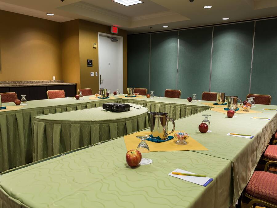 A conference room with a long table, chairs, and a projector.