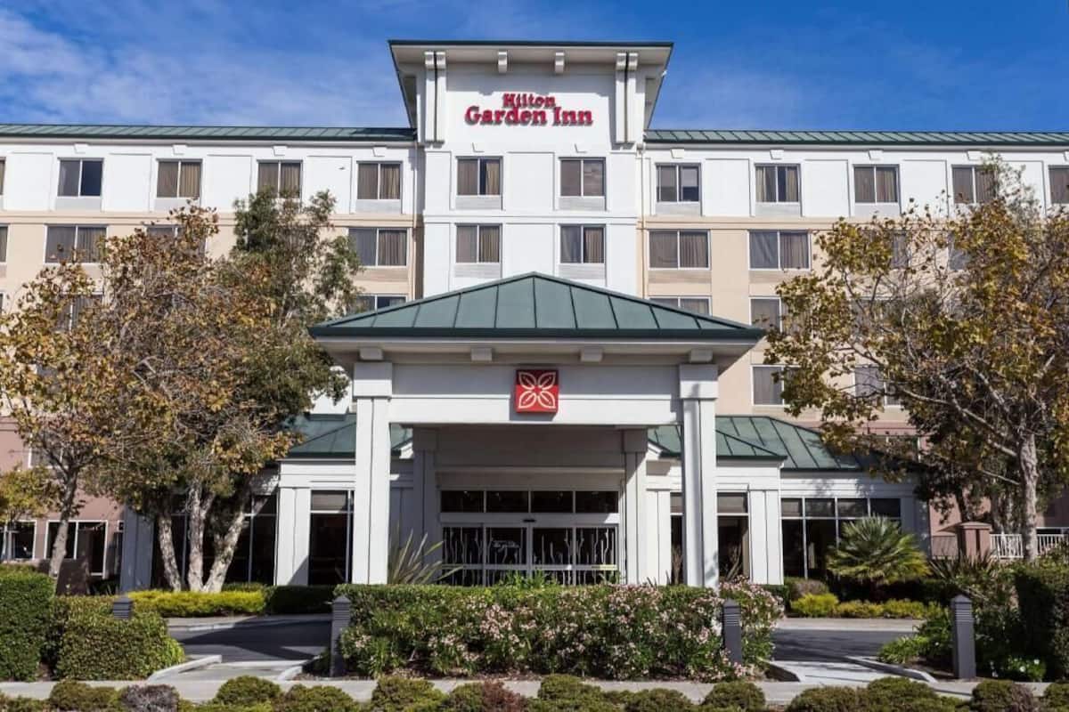 A Hilton Garden Inn with a central entrance, multiple windows, and a green roof.