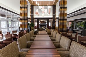 A spacious lobby with a central seating area, large windows, and modern lighting fixtures.