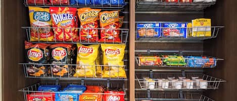 Una sección de aperitivos con distintas papas fritas y alimentos envasados.