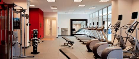 A gym with treadmills, elliptical machines, and weightlifting equipment.
