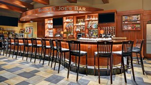 A bar area with multiple seating arrangements and a variety of liquor bottles. - Hilton Garden Inn Chicago Downtown/Magnificent Mile (Chicago)