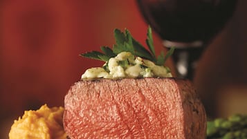 A steak with a garnish of herbs and a side of mashed potatoes.