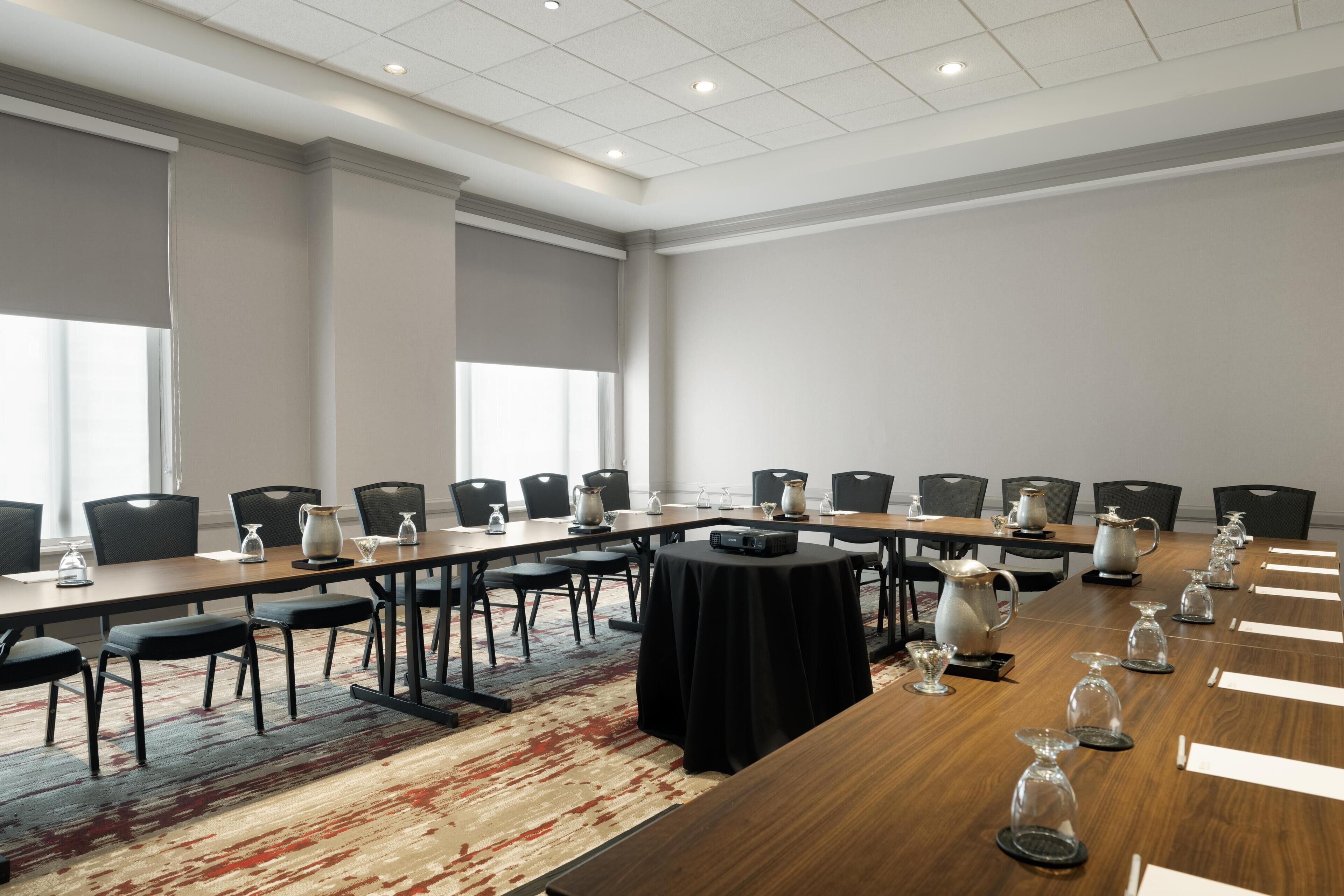 A conference room with a long table, chairs, and a black tablecloth.