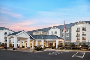 A hotel with a modern design, featuring a prominent American flag and a well-lit entrance. - Aloft by Marriott Mountain View (Mountain View)