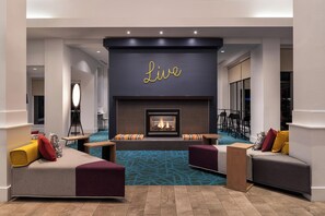 Un área de estar moderna con chimenea, asientos y un cartel que dice 'Live'.