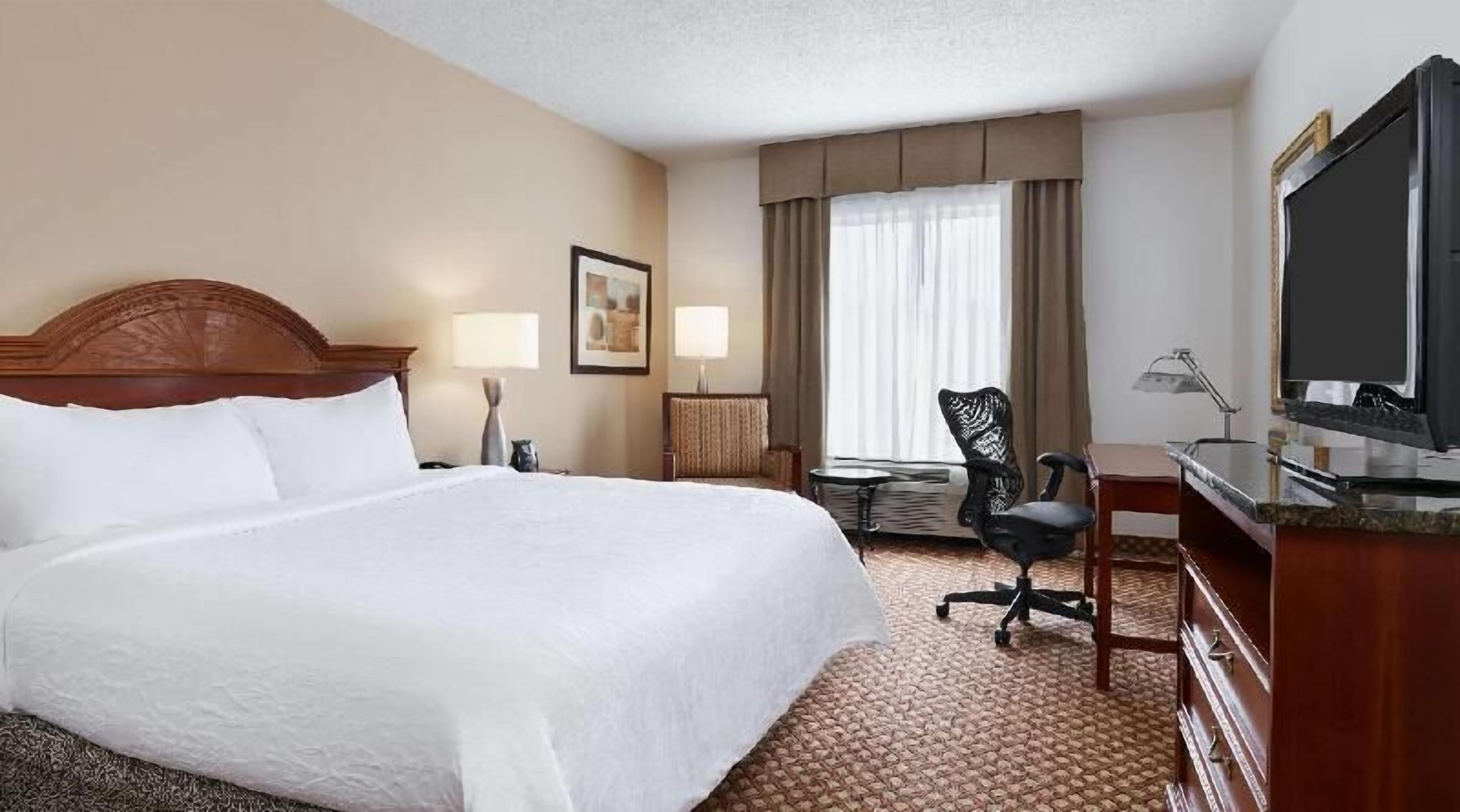 Premium bedding, desk, laptop workspace, blackout drapes