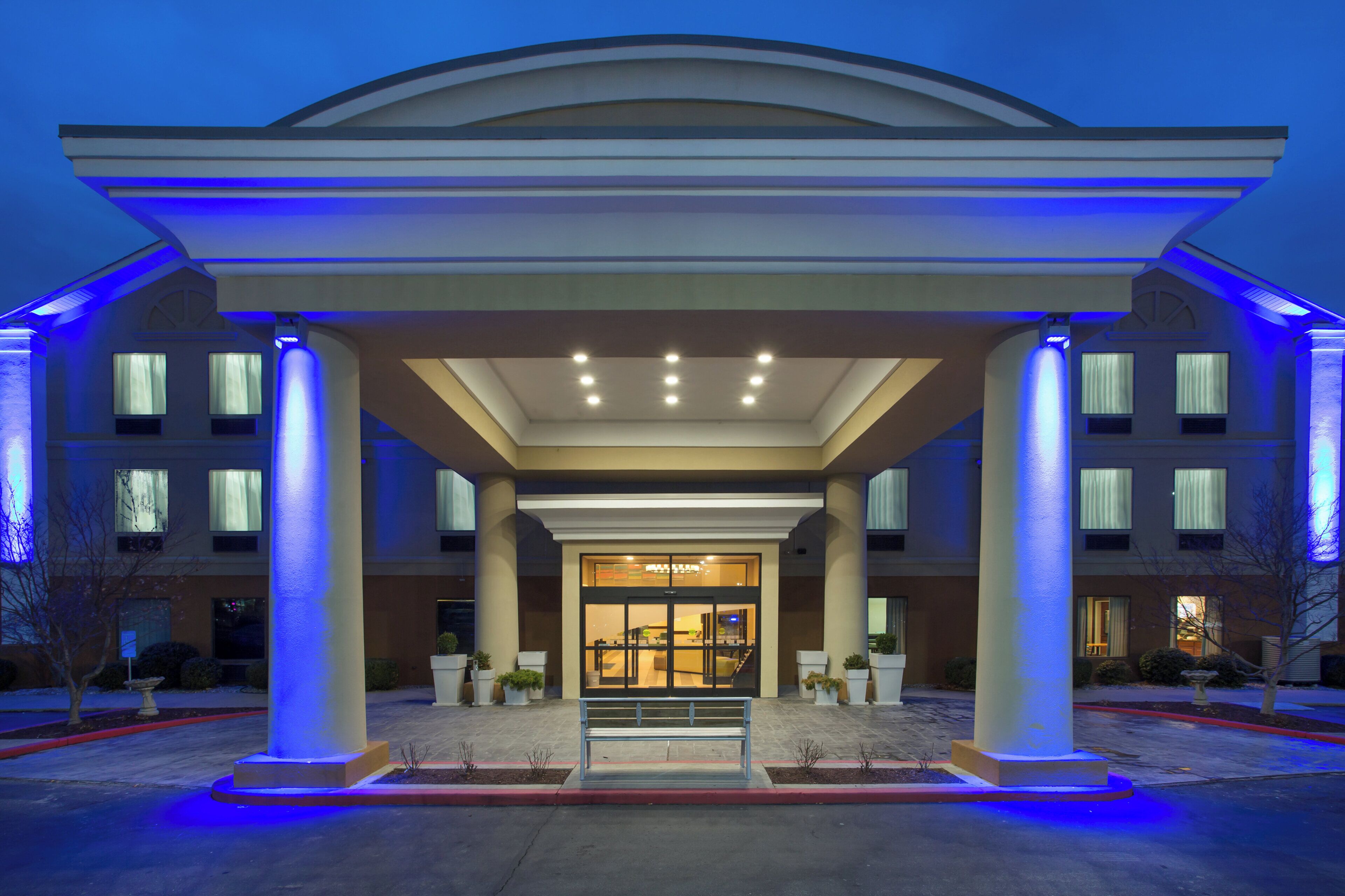 A hotel entrance with a covered walkway, columns, and a glass door entrance.