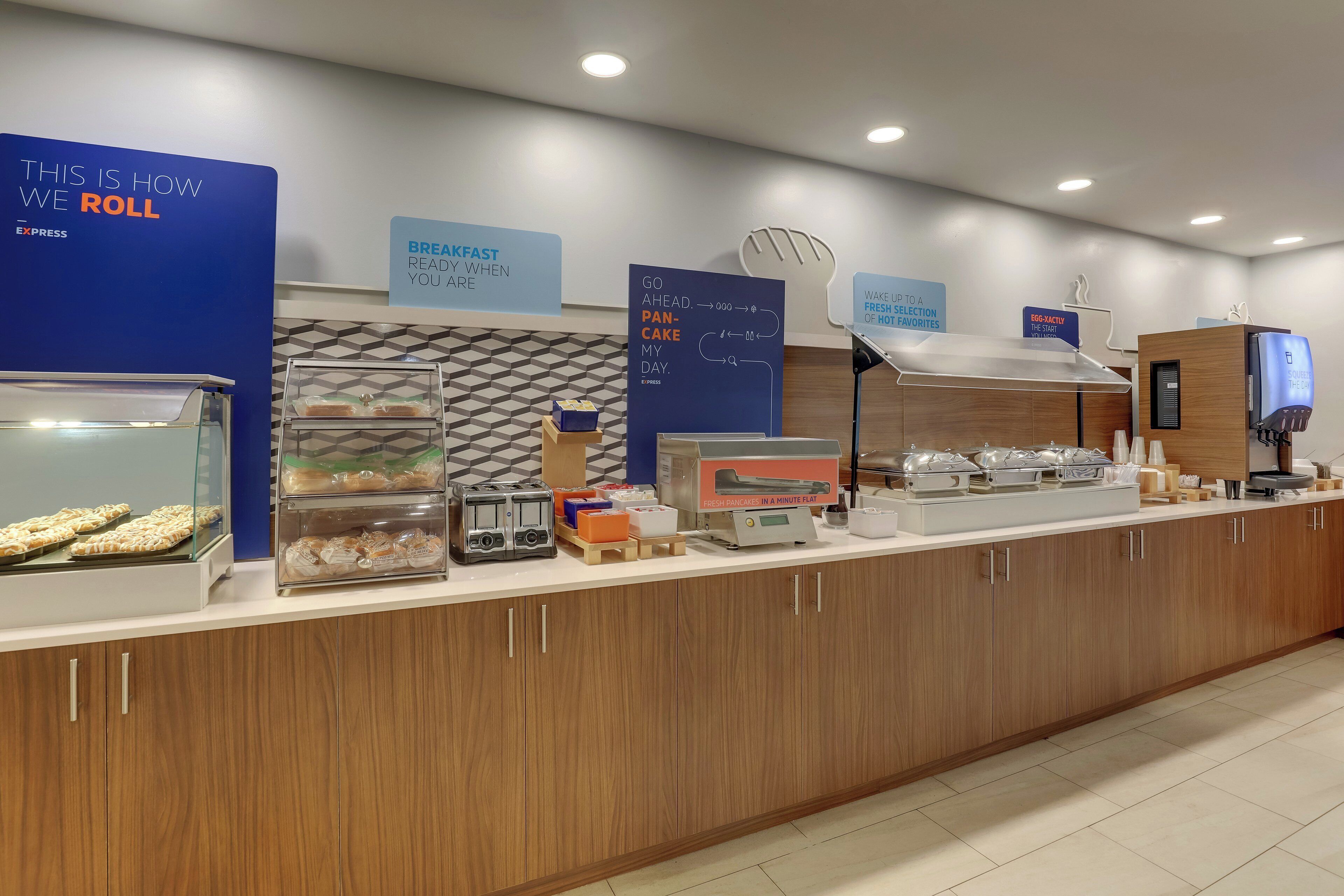 A breakfast buffet area with various food items and a sign indicating the process of rolling.