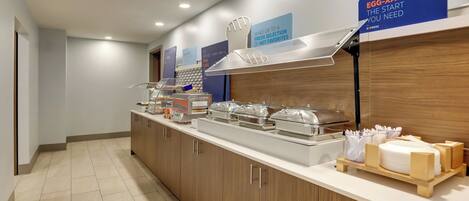A buffet setup with various food stations, including a sign that reads "EGG-XACTLY THE START YOU NEED".