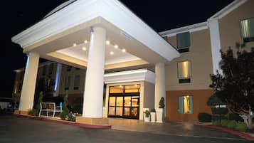 Ingresso di un hotel con portico, colonne e cartello che indica l'accesso.