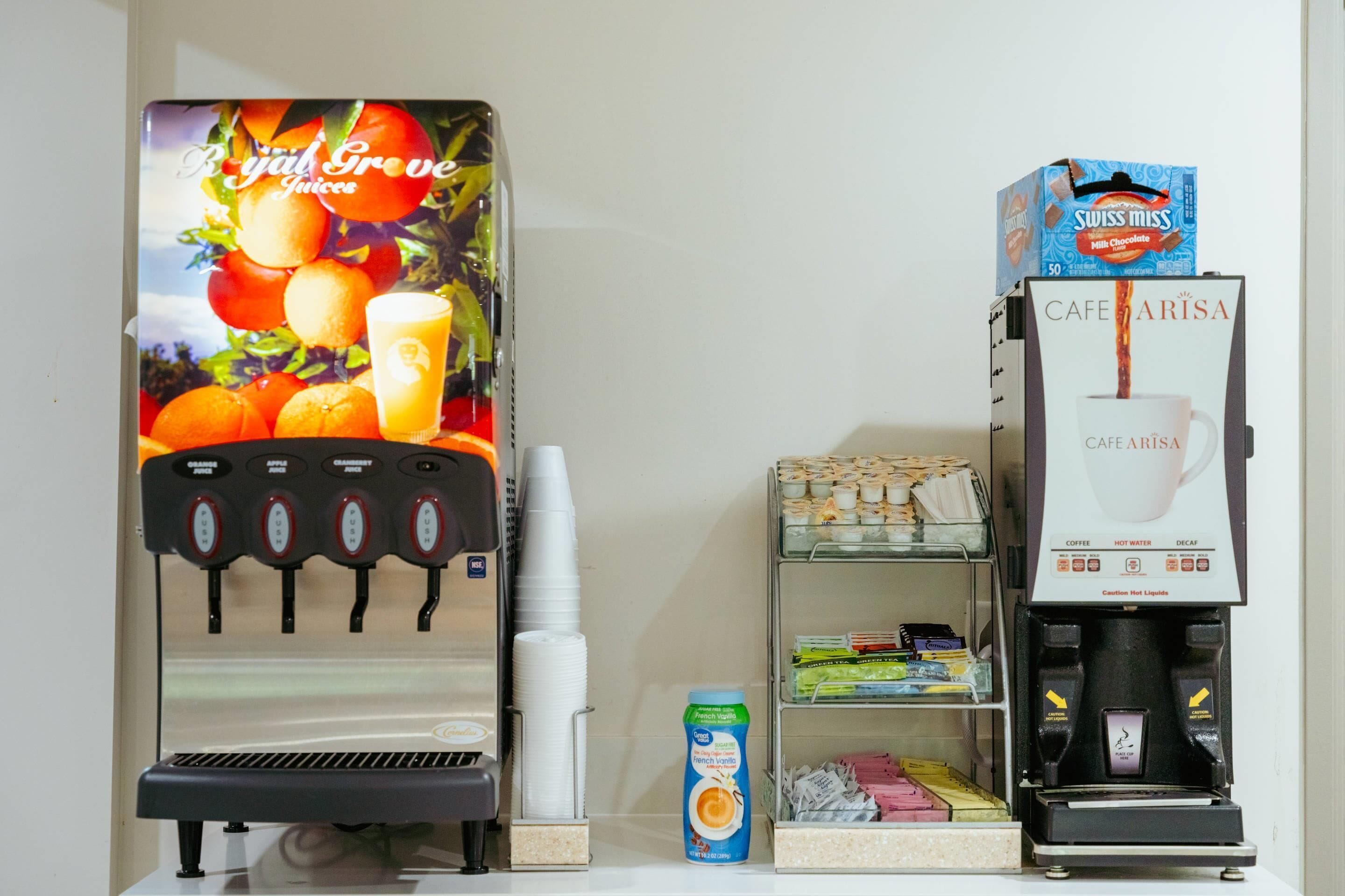 Una máquina de café con dispensador de chocolate con leche y dispensador de jugo.
