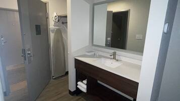 Une salle de bain moderne avec un double vasque, un grand miroir et un plancher en bois.