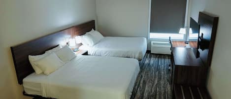 Habitación de hotel con dos camas, un escritorio con silla, televisor y ventana con persianas.