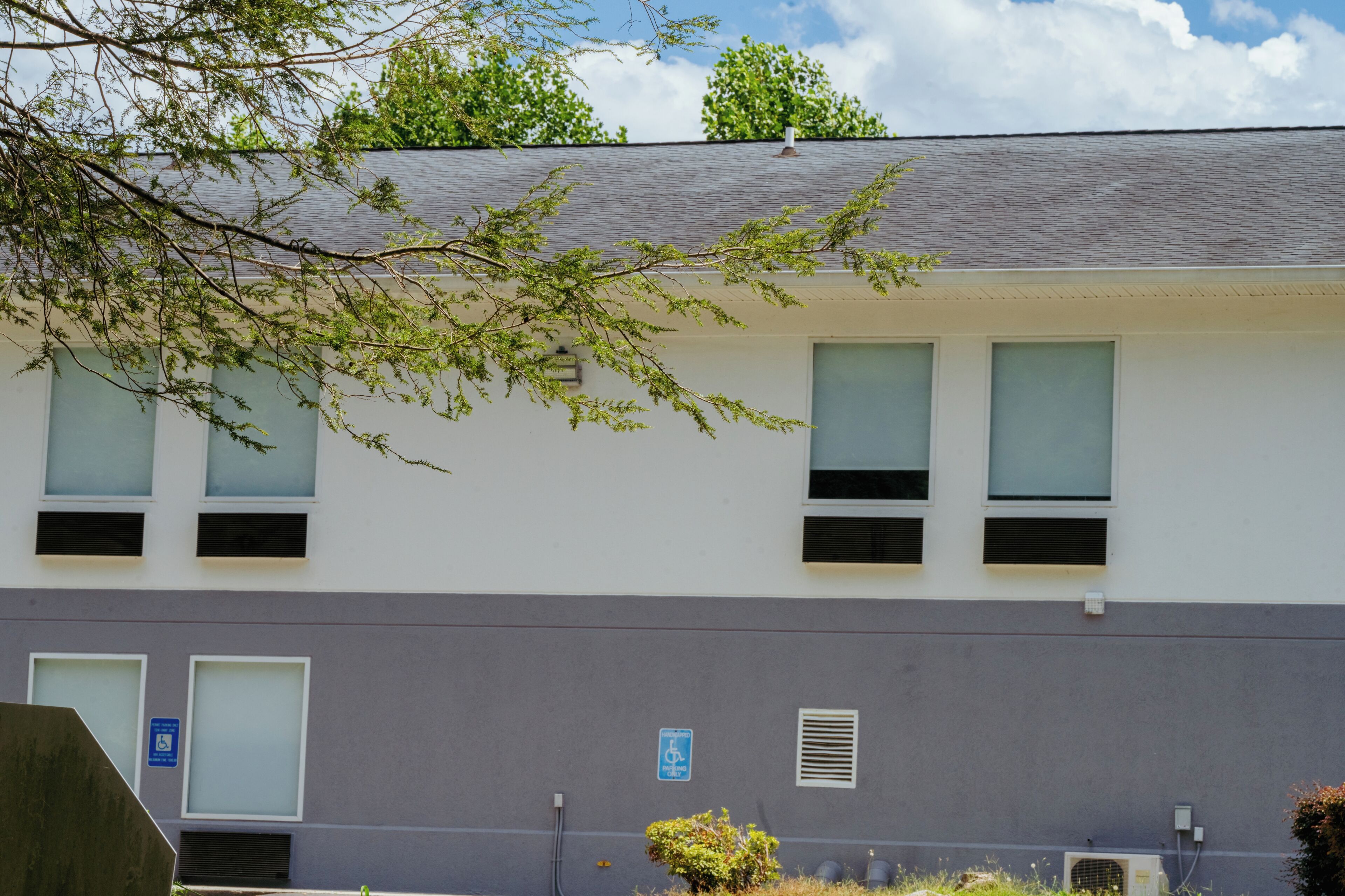 A building with a flat roof, multiple windows, and a sign indicating accessibility.