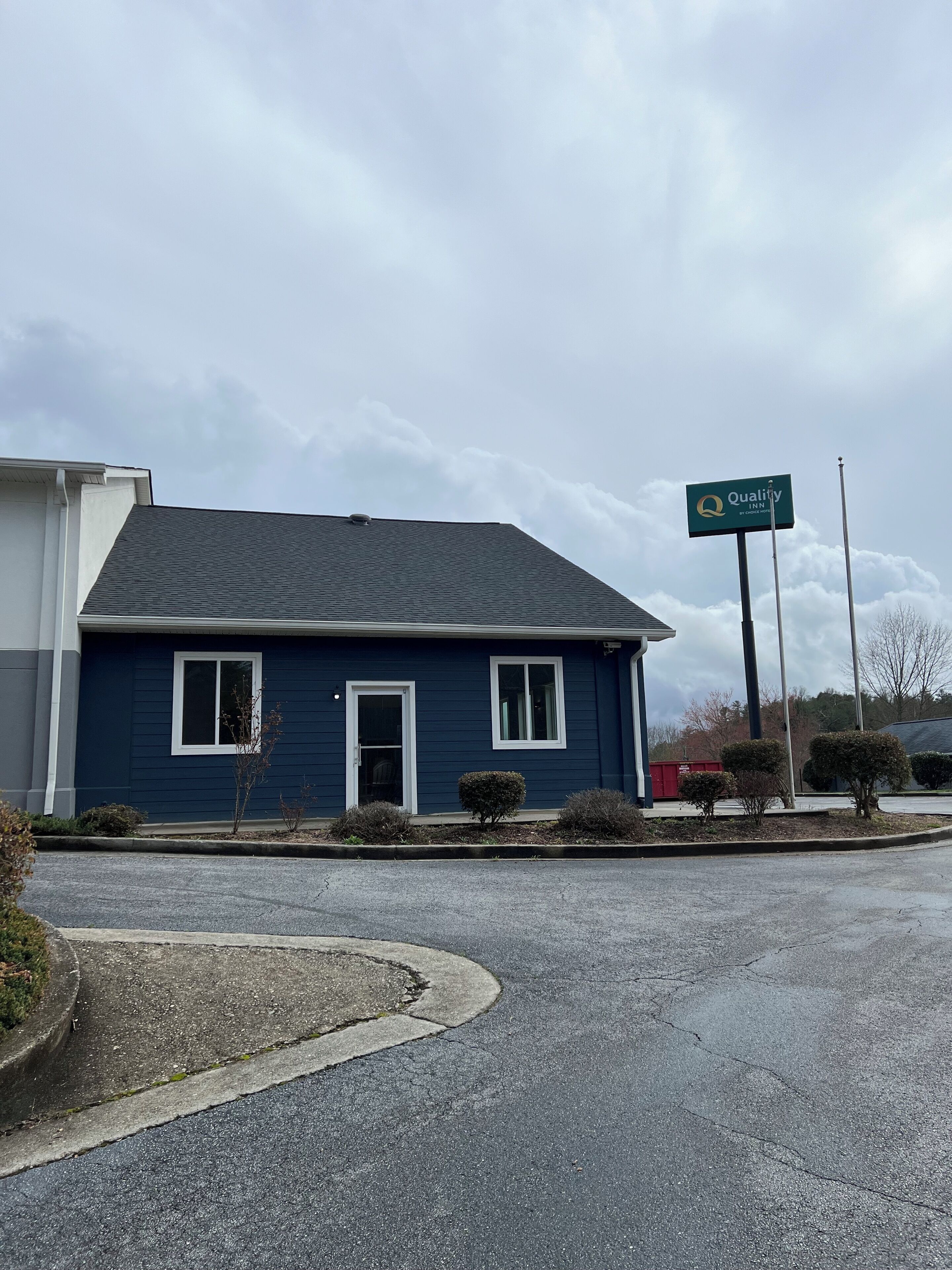 A blue building with a sign that reads "Quality Inn by Choice."