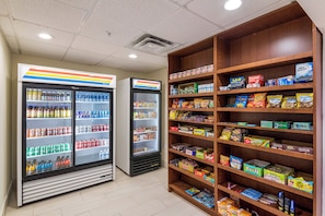 A snack and beverage vending area with multiple shelves stocked with various snacks and drinks. - Holiday Inn Express Hotel & Suites Columbus by IHG (Columbus)
