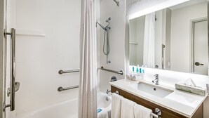 A modern bathroom with a bathtub, shower, and vanity with a mirror. - Holiday Inn Express Hotel & Suites Columbus by IHG (Columbus)