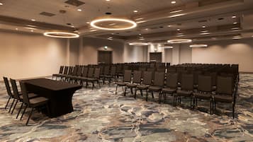 A conference room with a long table and chairs, a patterned carpet, and circular ceiling lights.