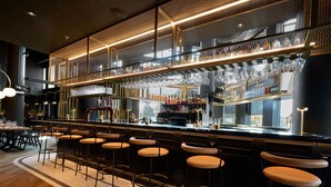 A bar area with stools, a bar counter, and a display of bottles. - Holiday Inn Hotel & Suites Ottawa Kanata by IHG (Ottawa)