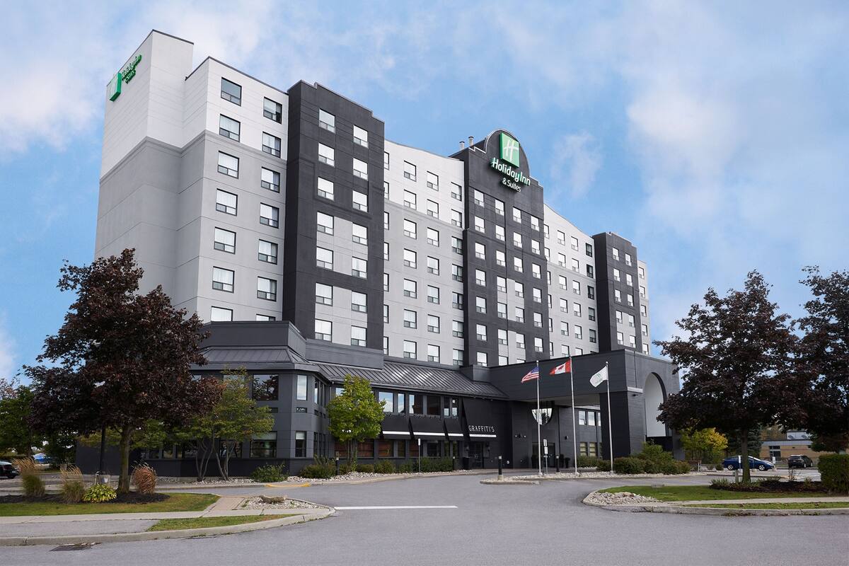 A Holiday Inn & Suites hotel with a modern design, featuring a prominent entrance and multiple floors.