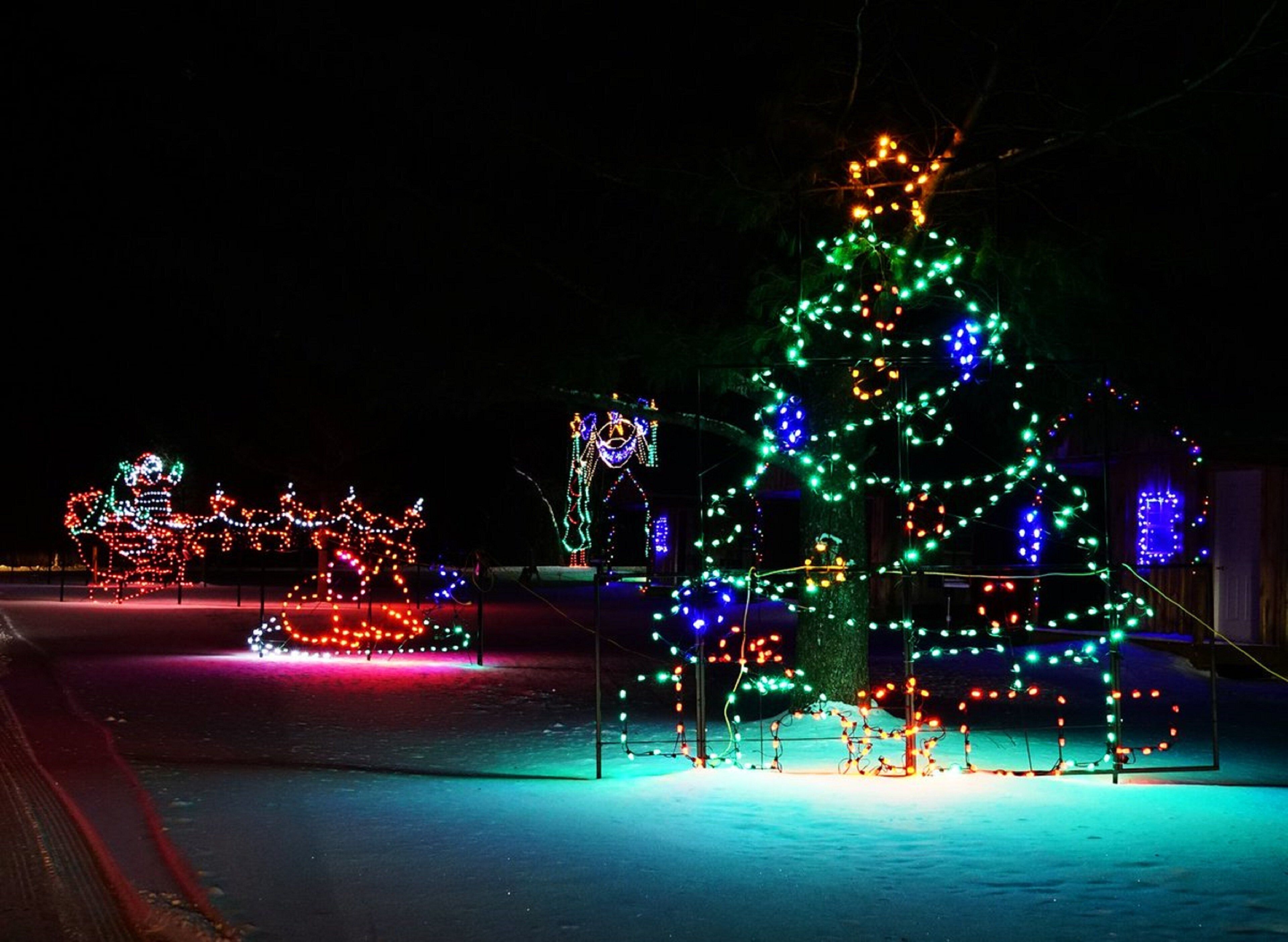 Árvore de Natal decorada e um trenó em um ambiente externo nevado.