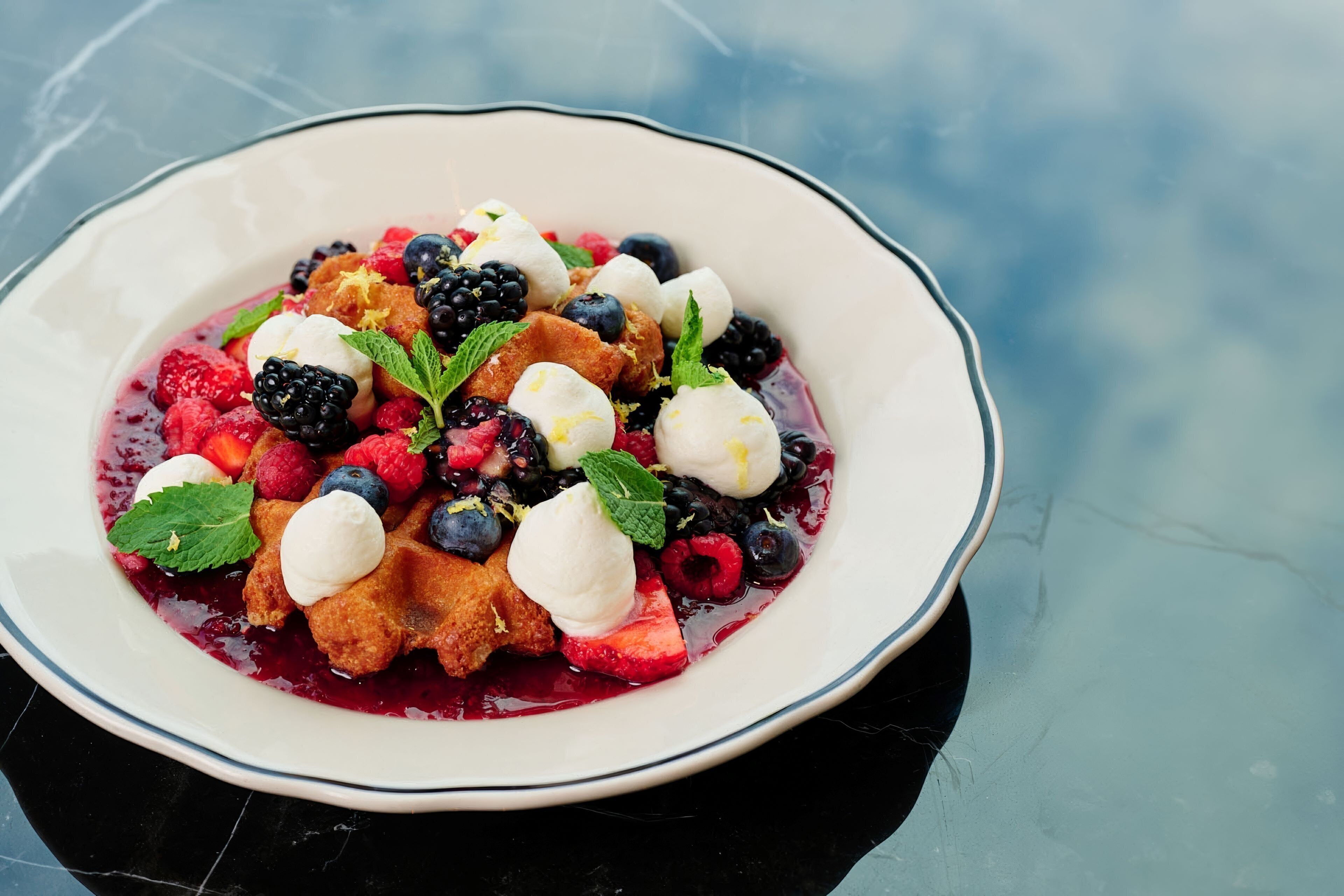 Un plato con postre, fruta y helado.