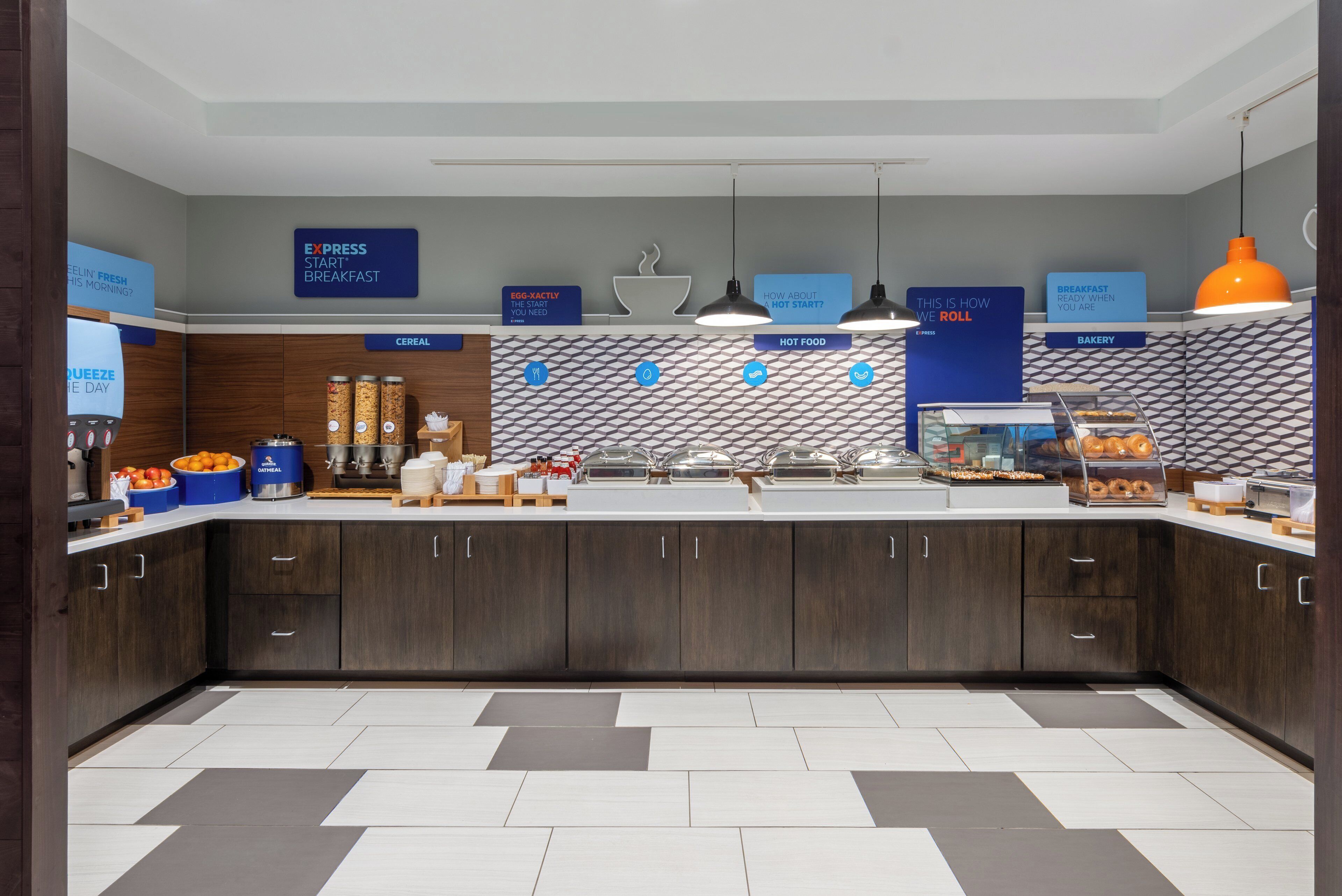 A modern breakfast area with a self-serve station, cereal, hot food, and bakery options.