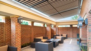 An outdoor patio area with brick walls, wicker furniture, and built-in planters.