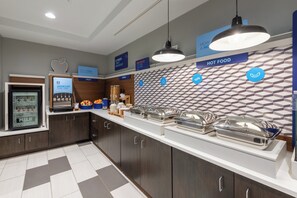 A modern breakfast bar with a variety of food options, including yogurt, eggs, and cereal, and a patterned wall design. - Holiday Inn Express State College at Williamsburg Square by IHG (State College)