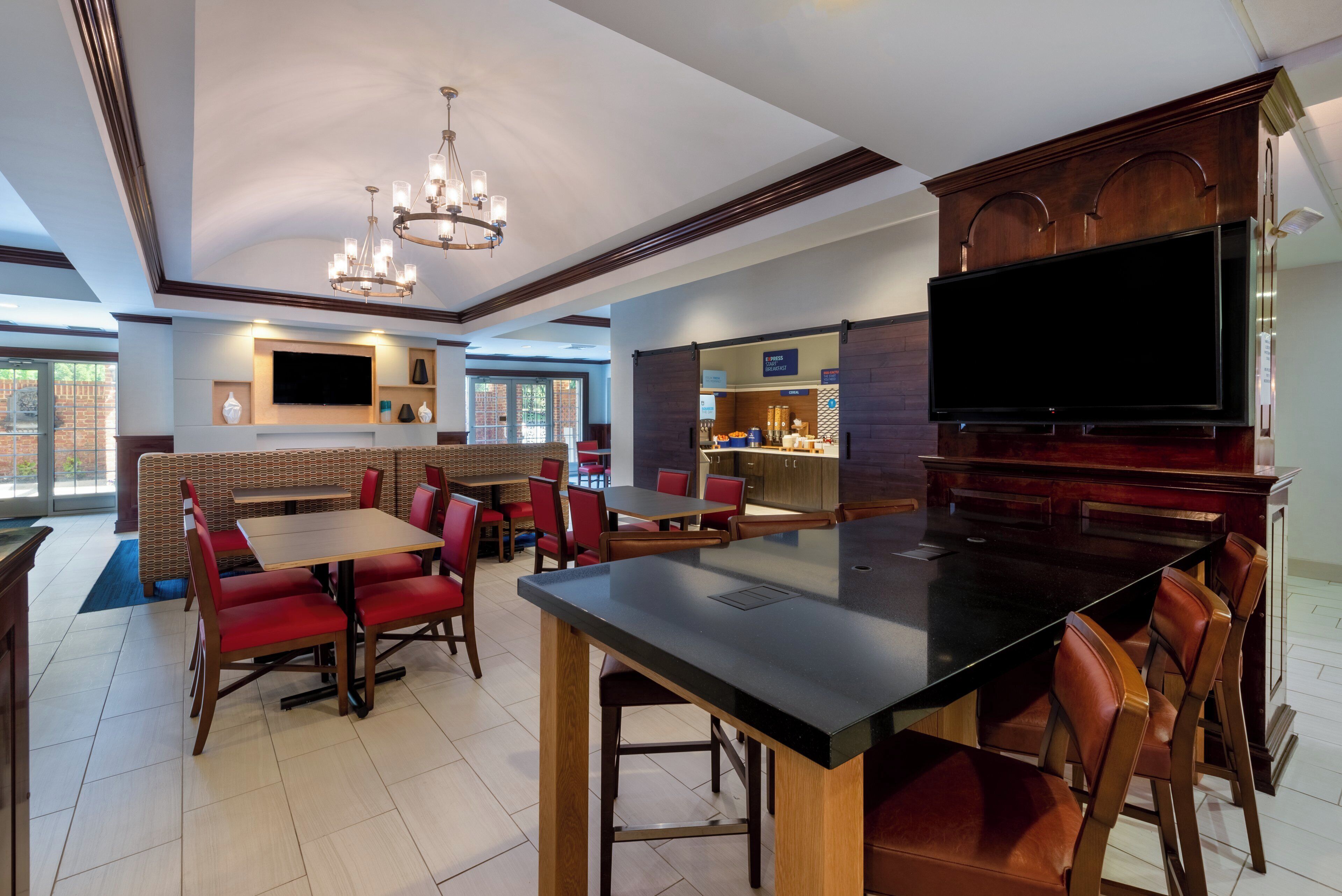 A restaurant with booths, a bar area, and a television screen.
