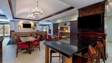 A restaurant with booths, a bar area, and a television screen.
