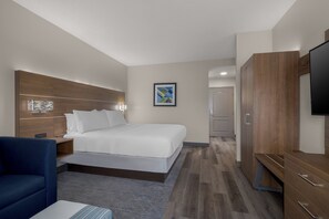 A modern hotel room with a bed, a desk, a chair, a wardrobe, and a television. - Holiday Inn Express Myrtle Beach-Broadway at the Beach by IHG (Myrtle Beach)
