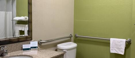A bathroom with a sink, mirror, toilet, and a towel rack.