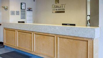 Eine Hotelrezeption mit einem Schild, auf dem 'QUALITY INN & SUITES BY CHOICE HOTELS' steht.