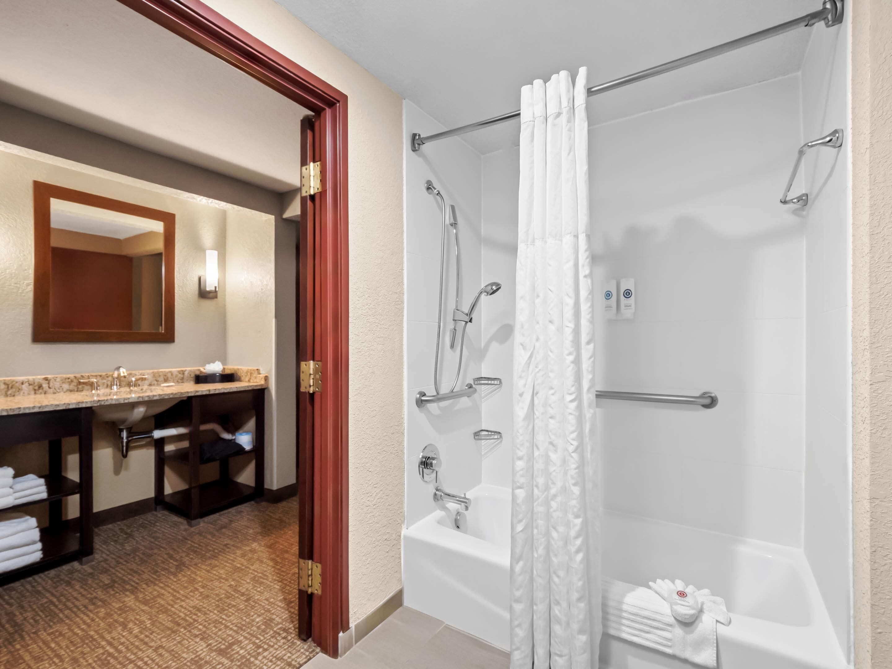 Une salle de bain équipée d’une baignoire, d’une douche et d’un meuble-lavabo avec un miroir.