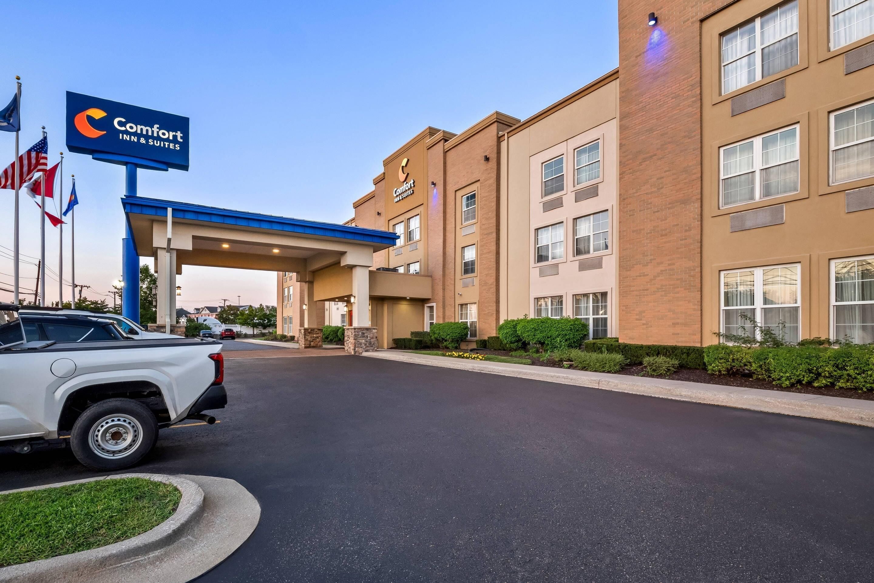 Edificio de Comfort Inn & Suites con un toldo azul y un cartel.