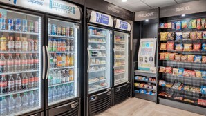 A Holiday Inn Express with Staybridge Suites and Replenish checkout areas, featuring refrigerated beverage dispensers and snack shelves. - Holiday Inn Express Federal Way Seattle South by IHG (Federal Way)