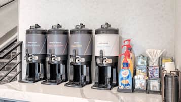 A coffee station with four dispensers labeled 'Dark Roast,' 'Regular Roast,' 'Decaf,' and 'Hot Water.'