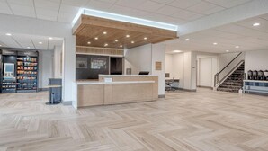 A spacious lobby with a wooden reception desk, a staircase, and a coffee station. - Holiday Inn Express Federal Way Seattle South by IHG (Federal Way)