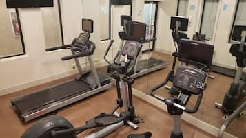 A gym with various exercise equipment including treadmills, an elliptical, and a stationary bike.